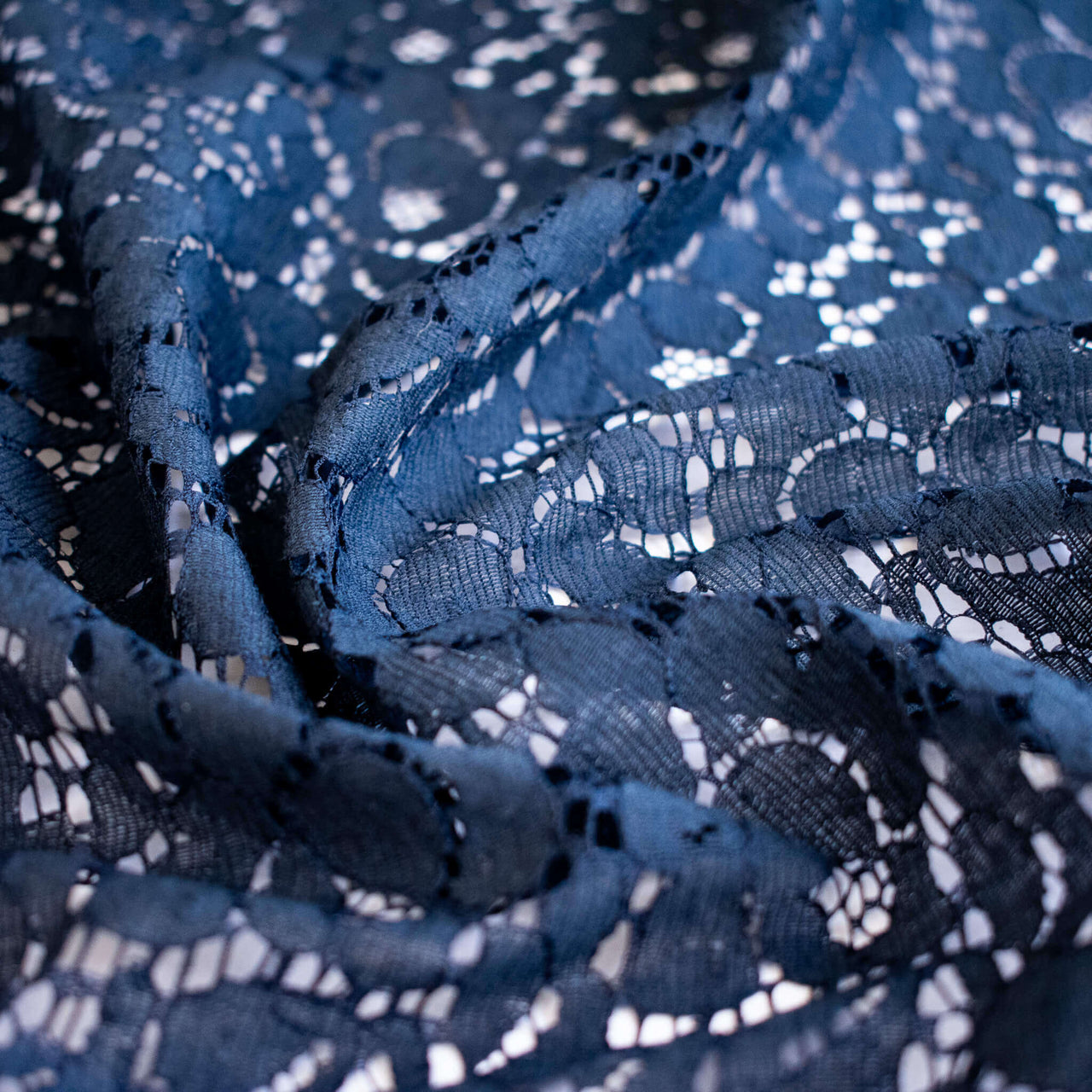 Close-up of blue lace fabric with floral pattern
