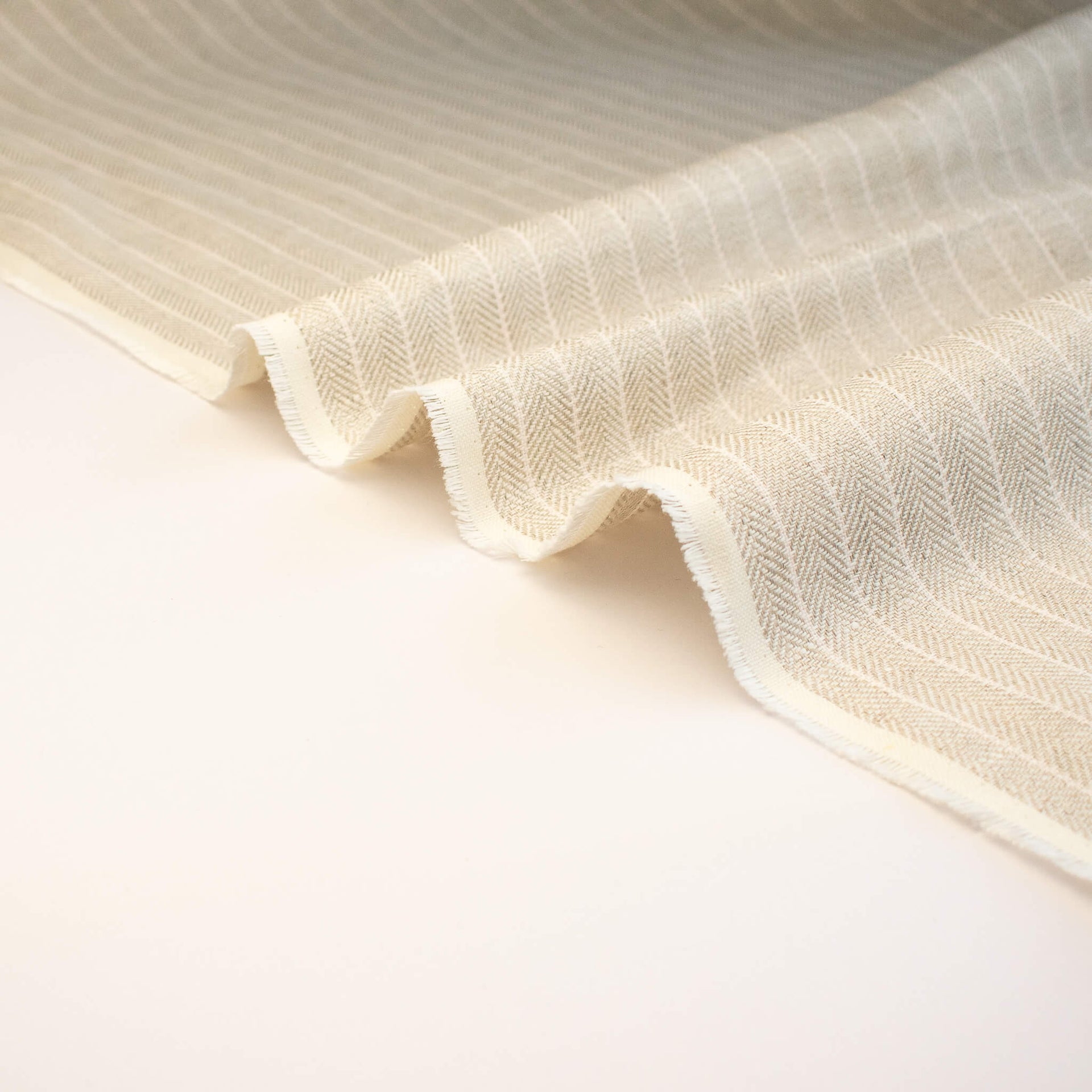 Close-up of European Mid-Weight 100% Linen Stripe Herringbone Weave fabric selvedge.