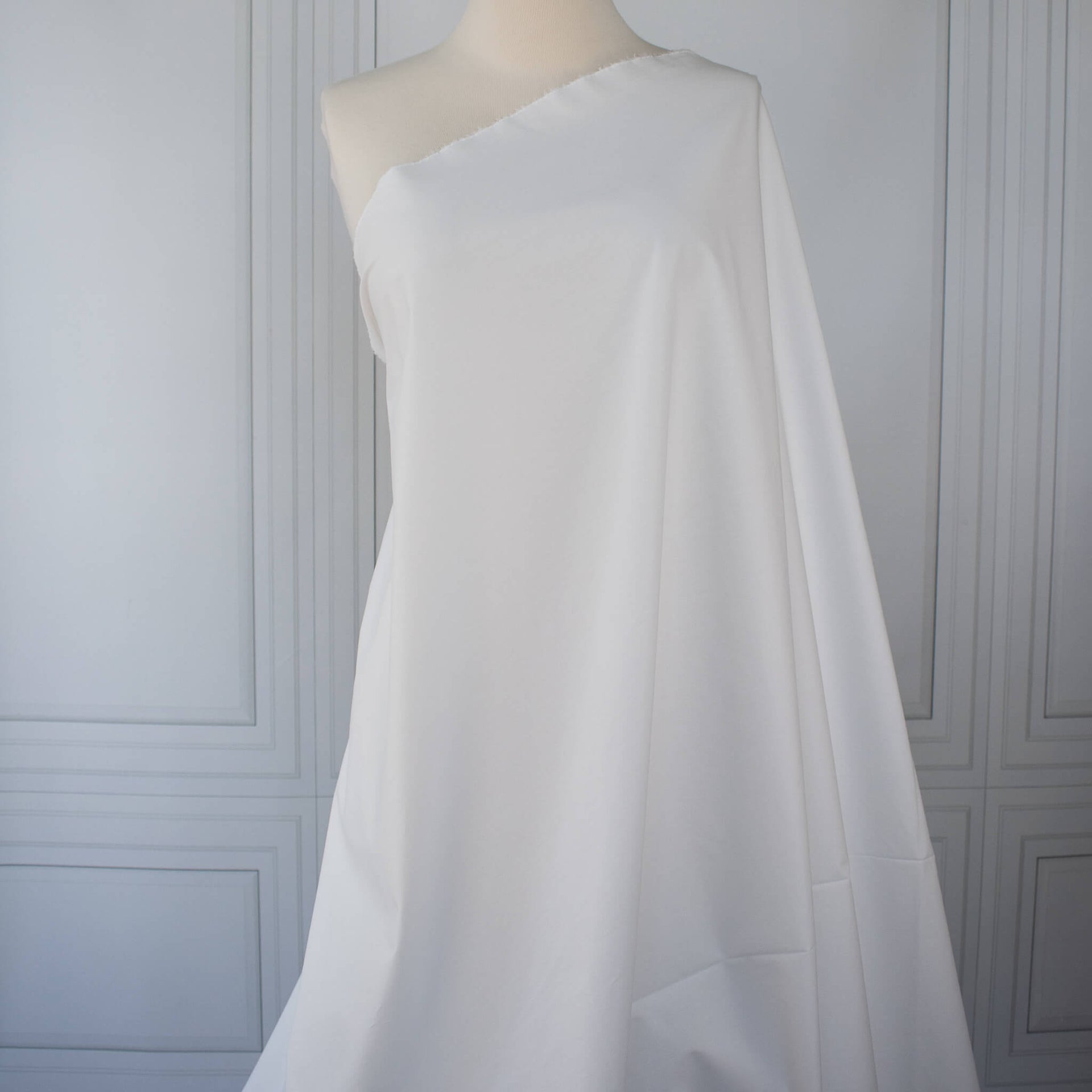 White NYC designer shirting fabric draped over a dressform