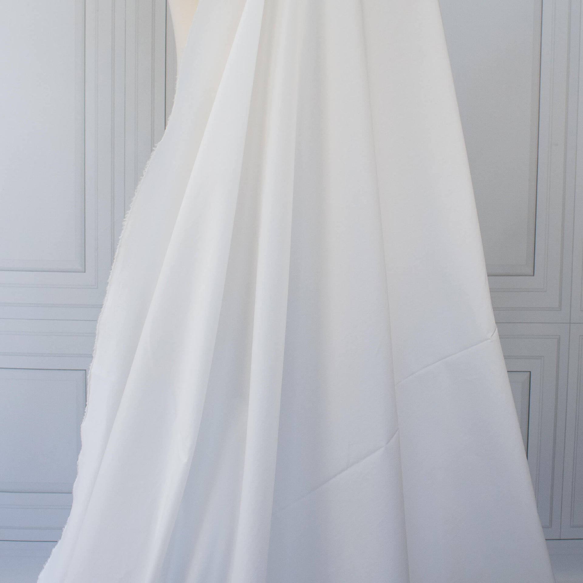White NYC designer shirting fabric draped over a dressform