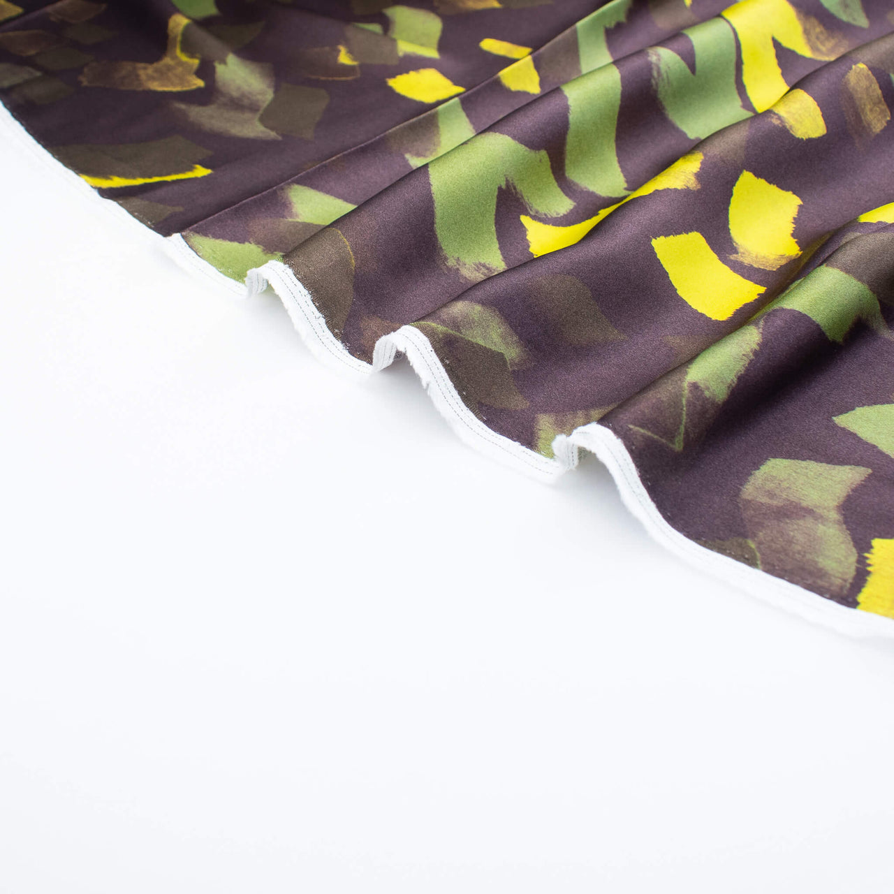 A close-up image of  Italian viscose sateen  fabric selvedge set against a plain white background.