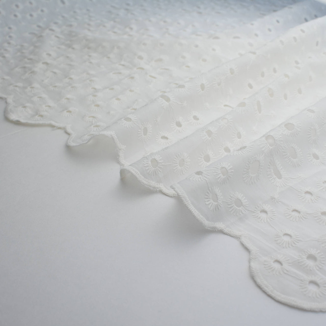 Image of  Italian Cotton San Gallo Lace in soft white, a delicate broderie anglaise fabric selvedge
