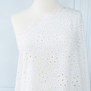 Image of  Italian Cotton San Gallo Lace in soft white, a delicate broderie anglaise fabric draped on dress form.