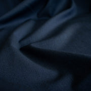 A close-up of draped Couture Italian wool and linen blend navy gabardine fabric  with soft folds 