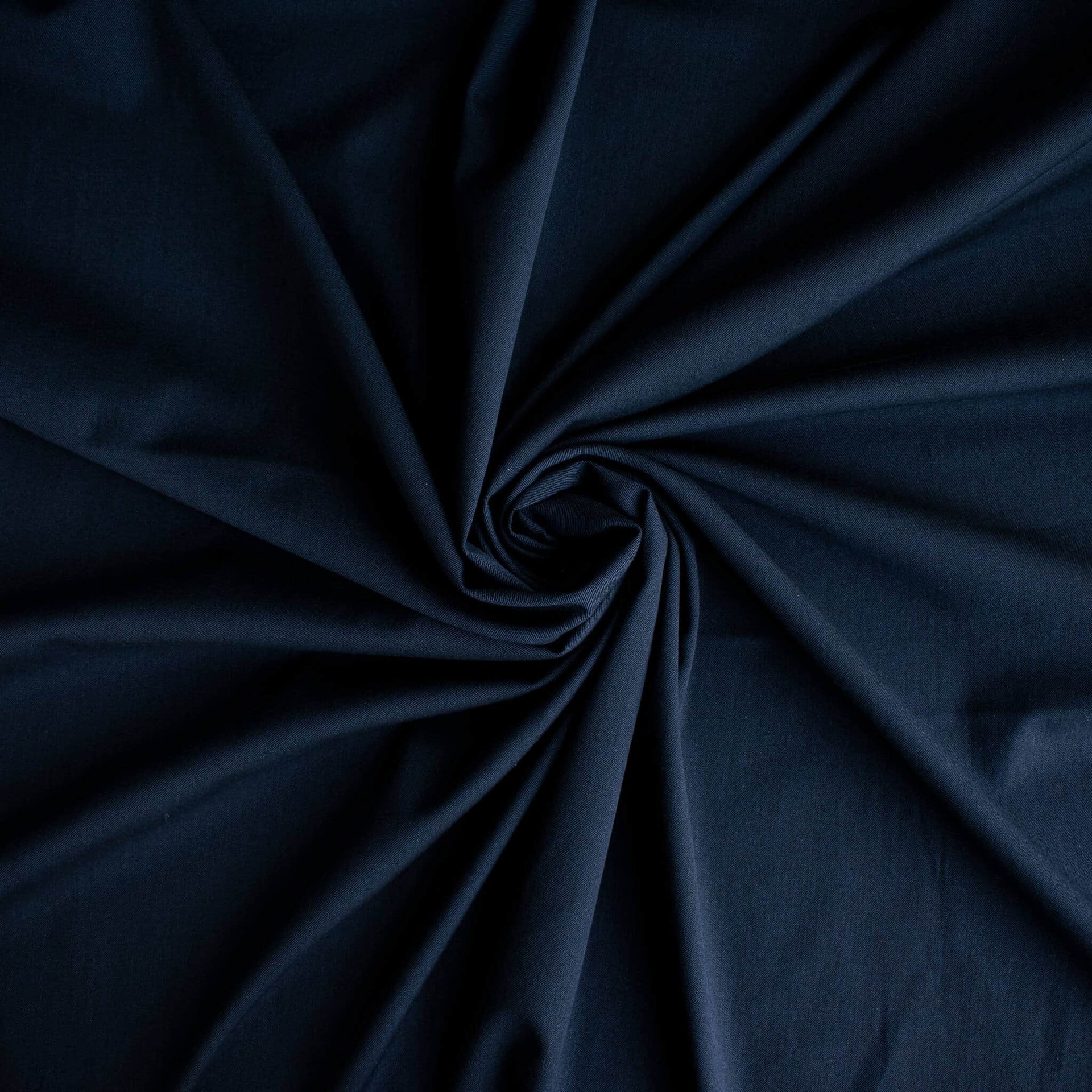Couture Italian wool and linen blend navy gabardine fabric draped in a spiral pattern to demonstrate fullness