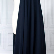 Couture Italian wool and linen blend navy gabardine fabric draped over a white dress form, set against a white paneled wall background.