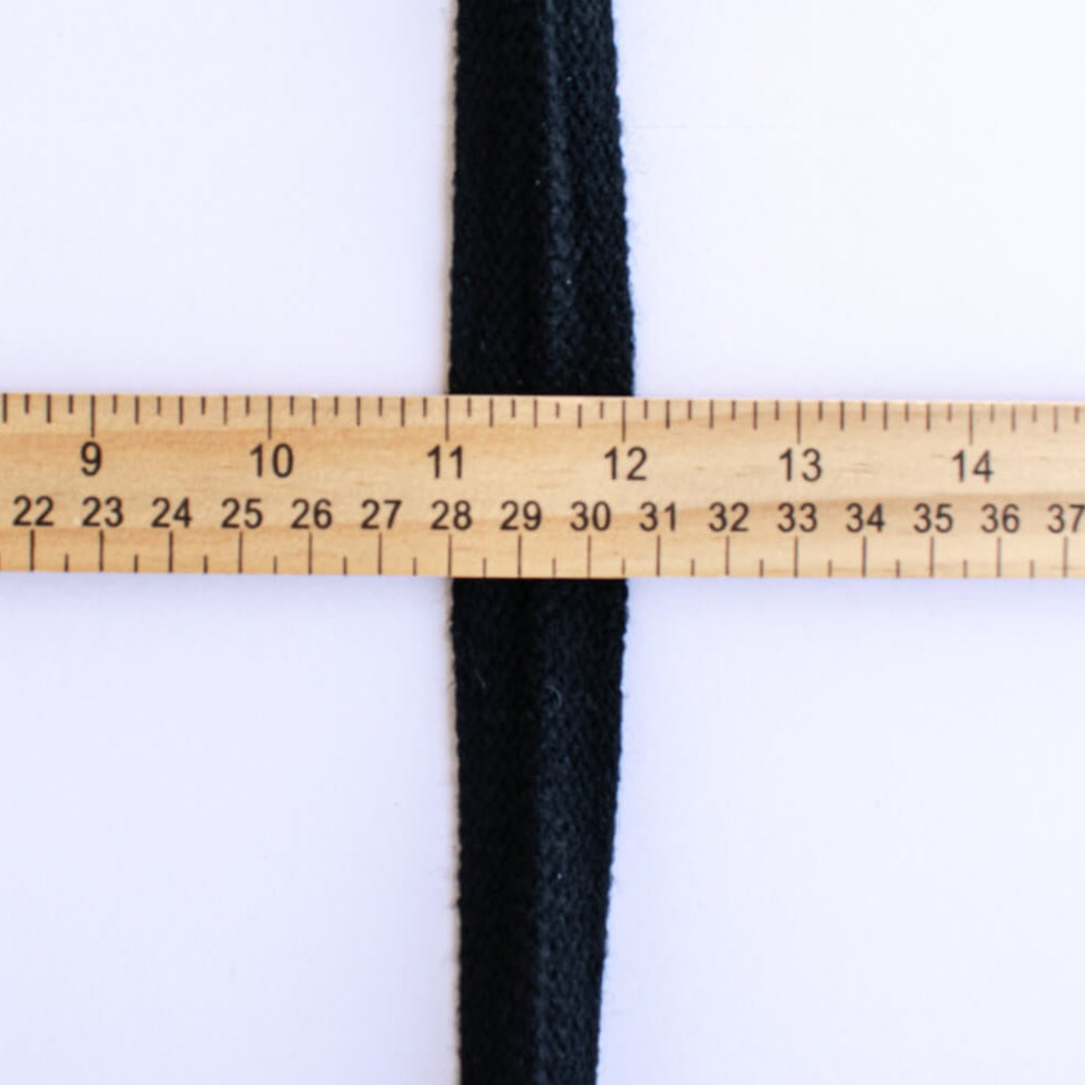 Vintage Foldover Black Braid Trim is back! This soft 1 inch trim can be folded to a sleek half-inch, perfect for a clean final touch on garment edges. Image of trim width and ruler.