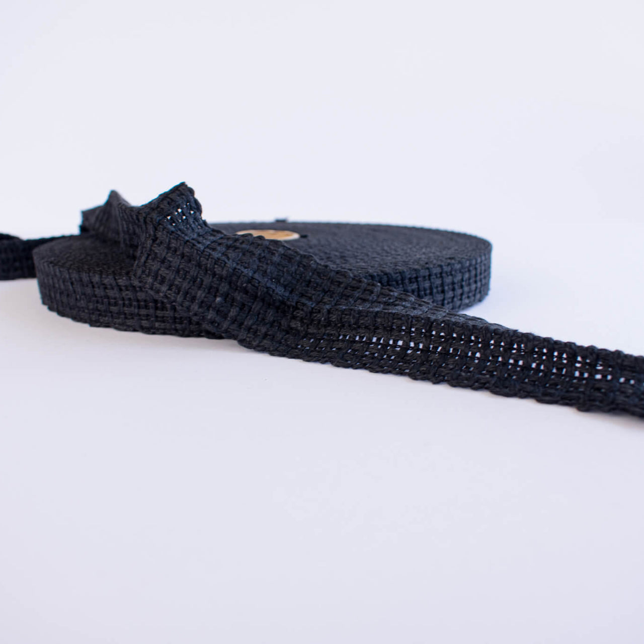 Vintage Foldover Black Braid Cotton Trim is back! This 1 and one-half inch trim can be folded to a sleek five-eighths of an inch creating a perfect clean finish for your sewing project. It also looks gorgeous as a base trim when layering trims for a designer look. Image of trim design.
