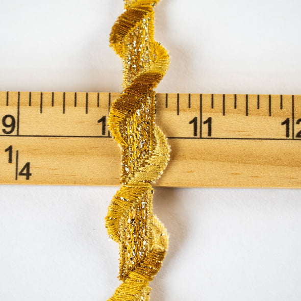 Bring a touch of couture to your project with our vintage gold double scallop trim. You’ll love the irresistible shades of gold scallops as they twist about a core of metallic golden threads. Whether you are embellishing a Classic French Jacket or a dress, this trim will add a timeless sophistication.  Pictured with ruler for width.