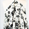 Image of draped couture black and creamy white floral Jacquard. This designer deadstock fabric by the yard features a stunning modern black daisy design set against a white shimmery jacquard.