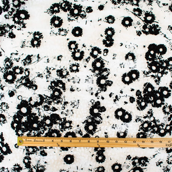 Image of couture black and creamy white floral Jacquard. This designer deadstock fabric by the yard features a stunning modern black daisy design set against a white shimmery jacquard.