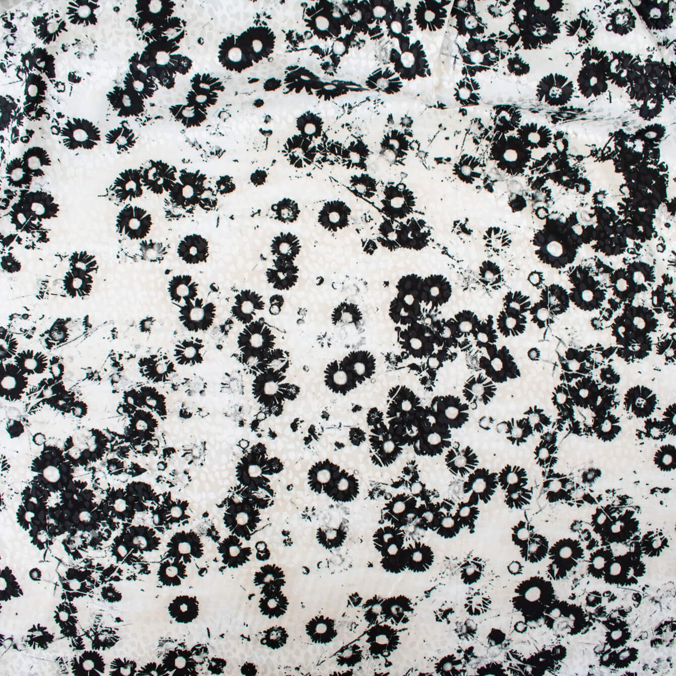 Image of couture black and creamy white floral Jacquard. This designer deadstock fabric by the yard features a stunning modern black daisy design set against a white shimmery jacquard.