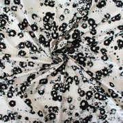 Image of couture black and creamy white floral Jacquard. This designer deadstock fabric by the yard features a stunning modern black daisy design set against a white shimmery jacquard.