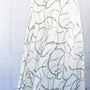 Famous Designer Chain Print Viscose Crepe Faille fabric by the yard. Chain links of tan and grey play upon an ivory background creating a whimsical yet sophisticated look. Slightly translucent with a lightly textured hand, this would make up gorgeous blouse or dress! Image of fabric drape.