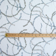 Famous Designer Chain Print Viscose Crepe Faille fabric by the yard. Chain links of tan and grey play upon an ivory background creating a whimsical yet sophisticated look. Slightly translucent with a lightly textured hand, this would make up gorgeous blouse or dress! Image of pattern scale with ruler.