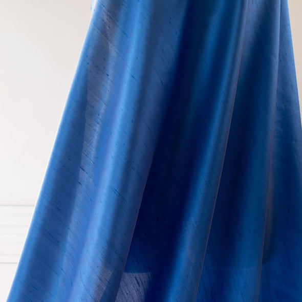 Italian silk shantung from a Beverly Hills Couture house is pure elegance. Lustrous with a slightly crisp, textured hand and in a gorgeous French blue too! Create something beautiful, perhaps an elegant dress, skirt, gown, or suit. Close up image of fabric drape.