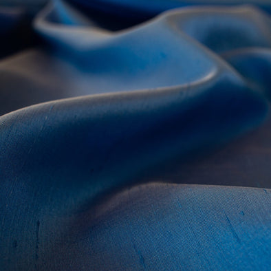 Italian silk shantung from a Beverly Hills Couture house is pure elegance. Lustrous with a slightly crisp, textured hand and in a gorgeous French blue too! Create something beautiful, perhaps an elegant dress, skirt, gown, or suit. Close up image.