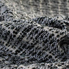 Imported from France, Black and white Jacquard with bits of silver metallic threading through out. Create a stunning French Jacket with this wool blend fabric. - Close up of fabric weave highlighting silver metallic threading