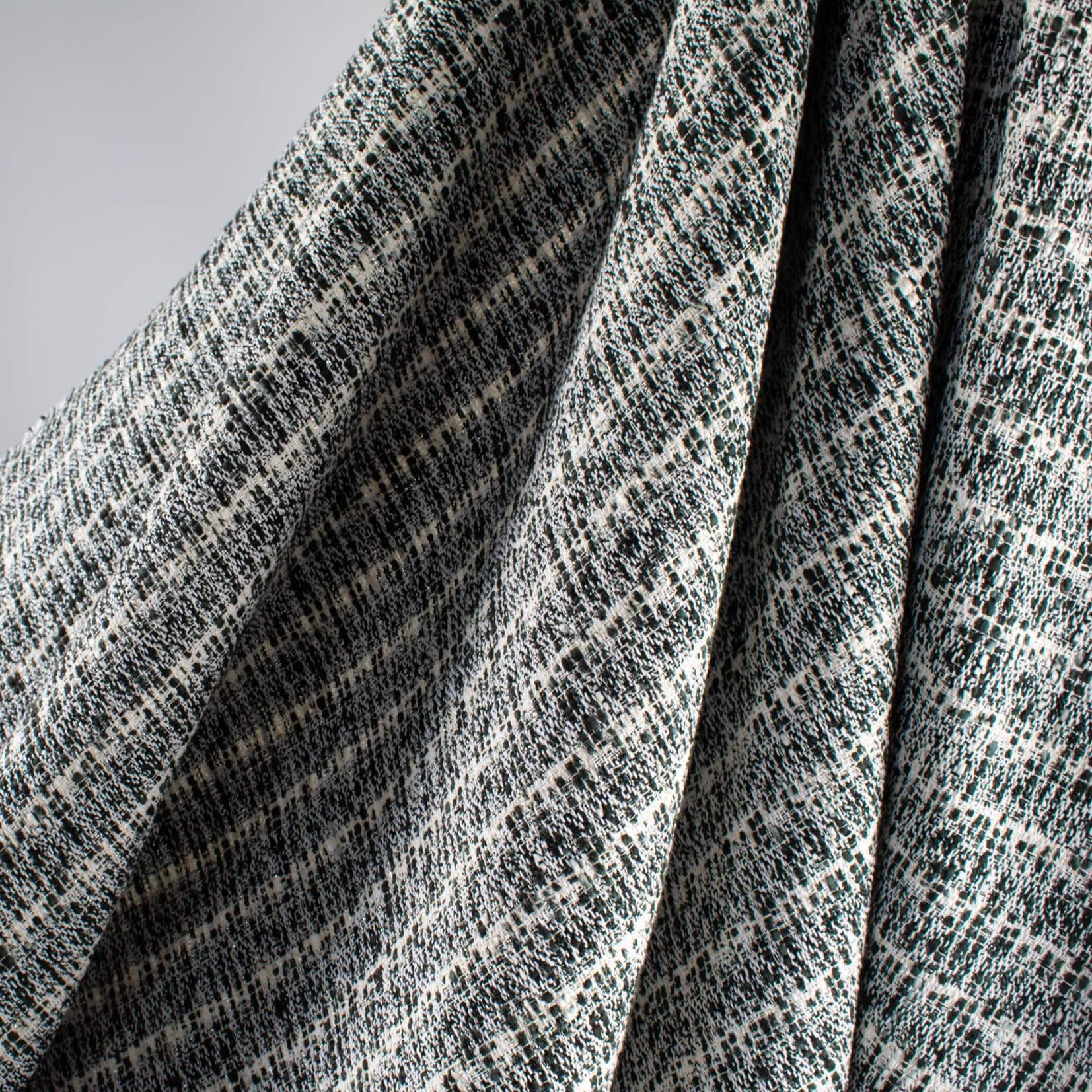 Close up of black and white jacquard fabric by the yard. Subtle silver metallic threads through out this wool blend suiting. Imported from France. Perfect for that Classic French Jacket! - image shows fabric drape