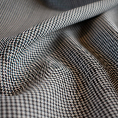 Reminiscent of 90's fashion this black and white tropical weight wool houndstooth is a true classic.  Can you picture the cutest straight skirt or very fashionable wide leg pant.  The tropical weight means you have the wear of a woolen and it is light enough to wear thorough each season. Close up image.
