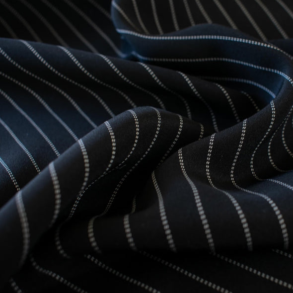 Gorgeous Couture Designer 4-Ply Silk Black with a white vertical double pinstripe, this premium medium weight silk has a soft sheen and gentle drape.  A fine smooth hand feels buttery on the skin, perfect for a wide leg pant, vest, jacket or dress!  Close up image.