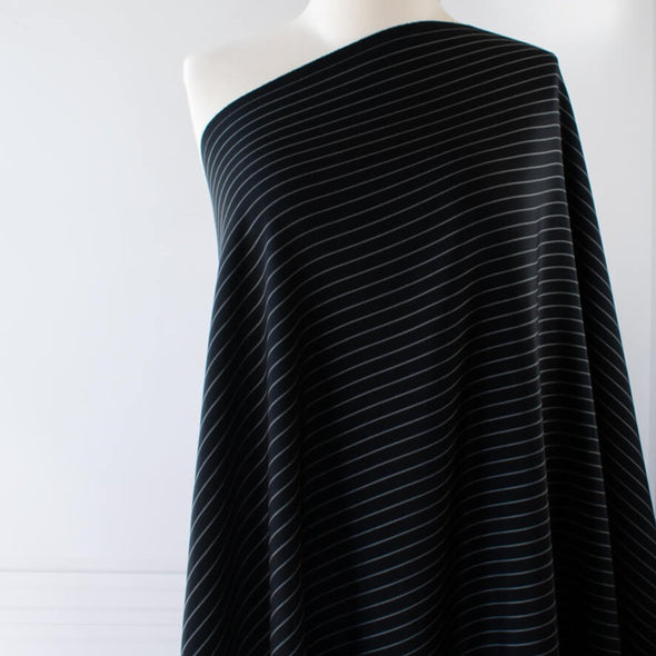 Gorgeous Couture Designer 4-Ply Silk Black with a white vertical double pinstripe, this premium medium weight silk has a soft sheen and gentle drape. A fine smooth hand feels buttery on the skin, perfect for a wide leg pant, vest, jacket or dress! Image of fabric draped on dressform .
