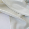 NYC Designer Couture silk/lycra stretch crepe de chine in a fantastic width. The soft, semi-textured fluid drape of this pale grey crepe will create a lovely dress or top for your next sewing adventure. Photo of fabric selvedge.