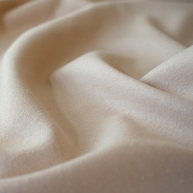 LA Designer silk noil in a soft creamy ecru. A nice fabric for tailored and loose-fitting styles!  Perfect for a wide-leg  pant, or a tailored shirt dress or casual jacket.   Close up image