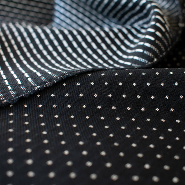 Luxurious designer suiting in black with a white and gold metallic running stitch. Take sophistication up a notch in this gorgeous wool blend with a soft and supple hand. Perfect for a glamorous tailored suit or jacket. Image of face side and running stitch side of fabric.