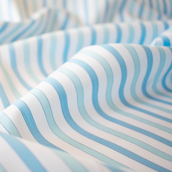 Designer striped cotton shirting that is soft, silky and "Fresh as Air"!  White, powder blue and sky blue woven vertical stripes will bring a freshness to your style.  Perfect for summer dresses, the classic shirtdress, a classic tailored shirt, or tunic. Close up image.