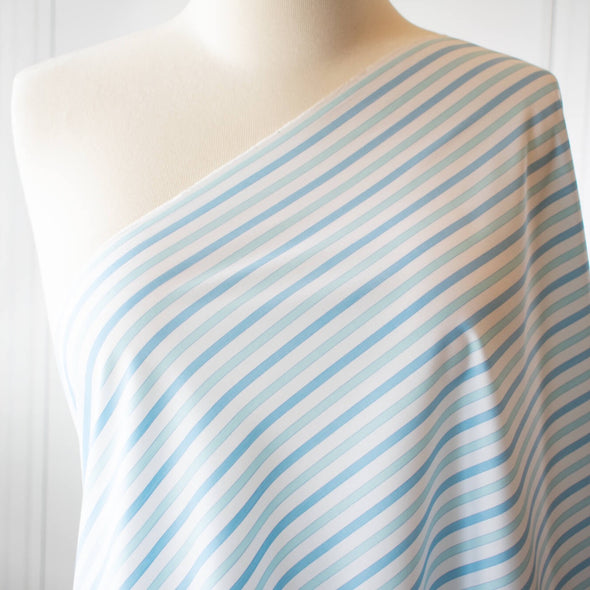 Designer striped cotton shirting that is soft, silky and "Fresh as Air"!  White, powder blue and sky blue woven vertical stripes will bring a freshness to your style.  Perfect for summer dresses, the classic shirtdress, a classic tailored shirt, or tunic. Image of fabric draped on dress form.