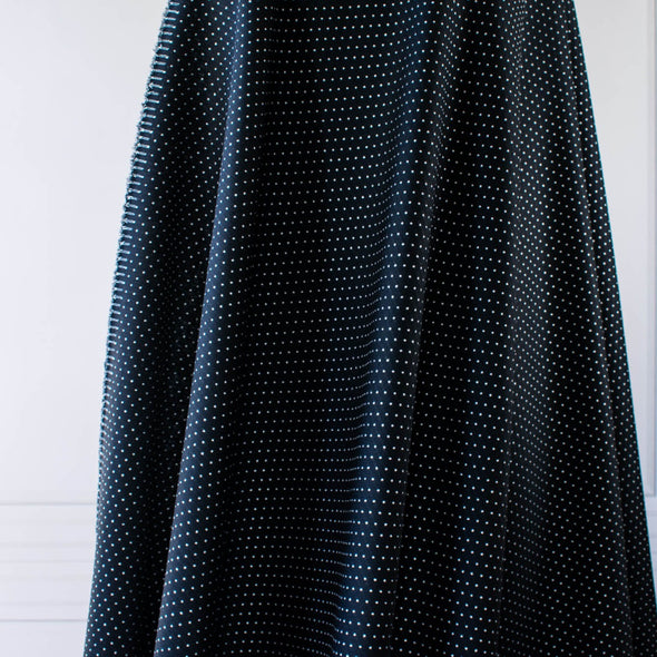 Luxurious designer suiting in black with a white and gold metallic running stitch. Take sophistication up a notch in this gorgeous wool blend with a soft and supple hand. Perfect for a glamorous tailored suit or jacket. Image of fabric drape.