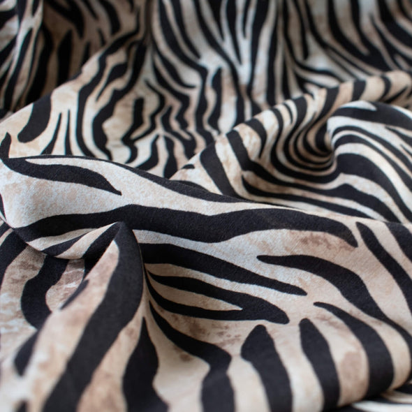 Famous Designer Rayon Challis flowy and soft animal print in tan white and black. Photo depicts fabric body.