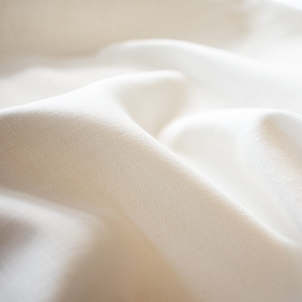 From a designer known for sophisticated and minimalist designs, you'll fall in love with this absolutely stunning Italian linen blend in a soft pearly white.   Slightly crisp with a soft hand and on the lighter side of a mid-weight. Perfect for more tailored garments... maybe a summer sundress! Close up image.
