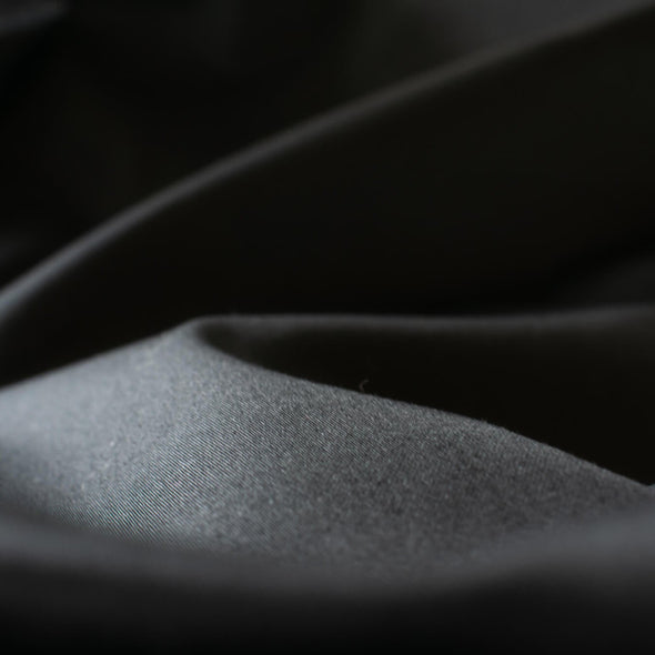 The lustrous sheen in this famous dress designer stretch sateen is a sure standout. In matte black, it has a smooth thin hand and will sew up a perfect year round garment. Opaque and a bit of stretch, not only will you look stunning but it's comfortable too! Close up image.