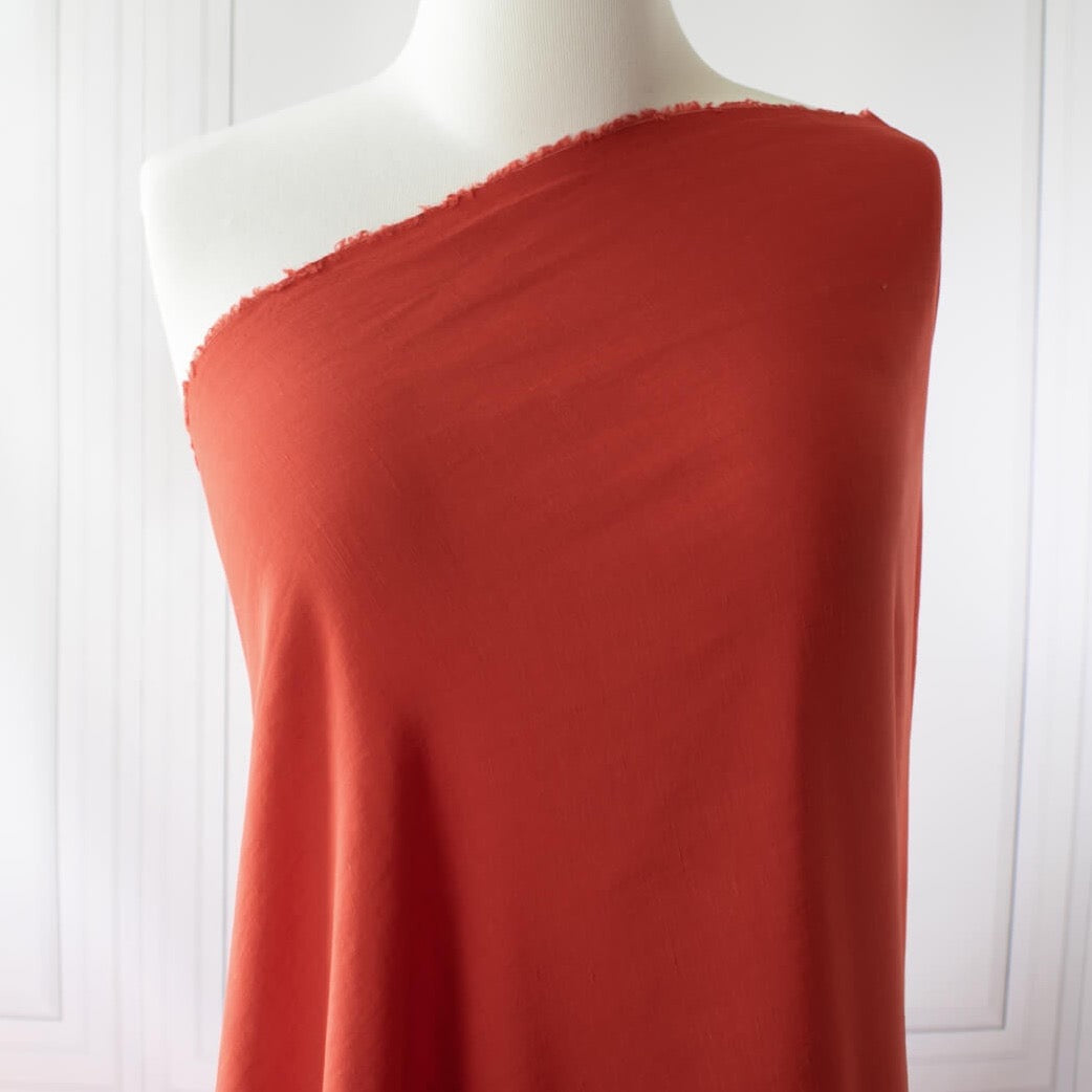 Richly saturated in color, this linen blend has a soft, textured hand and the familiar drape of rayon. Make up a gorgeous top, dress or skirt that stands out!  Translucent with a pleasing slubbed texture, may need lining for dresses and skirts. Image of fabric draped on dress form.