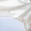 Designer dead stock fabric in a silky champagne polyester charmeuse. Canadian designer. Image of selvedge edge.