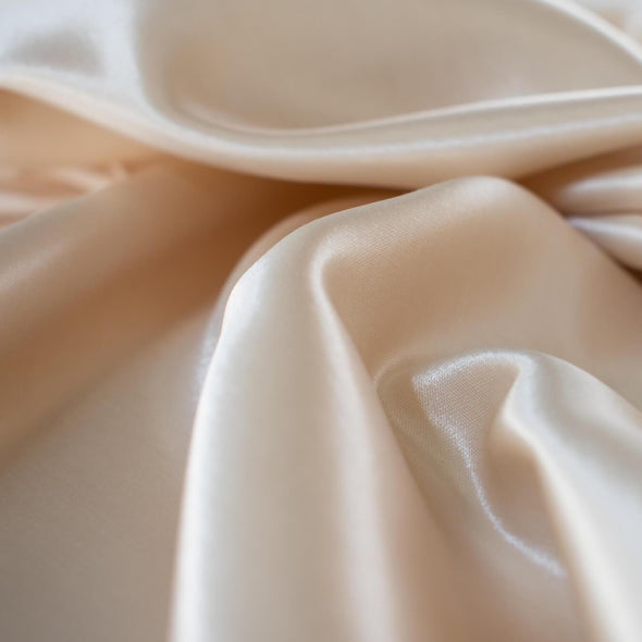 Designer dead stock fabric in a silky champagne polyester charmeuse. Canadian designer.