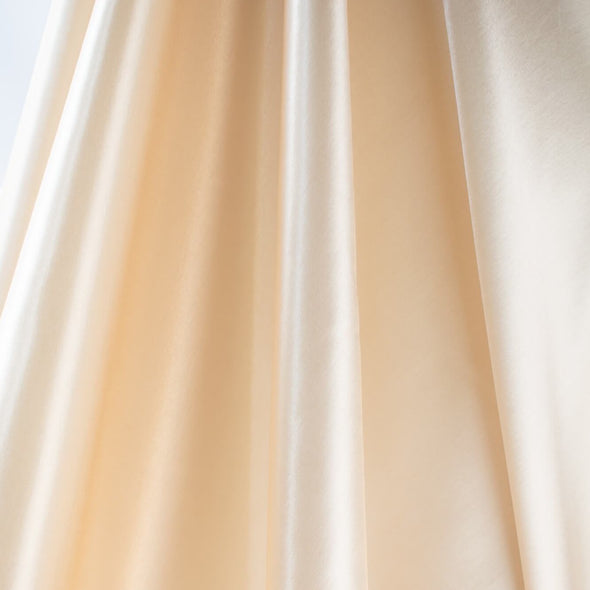 Designer dead stock fabric in a silky champagne polyester charmeuse. Canadian designer. Image of fabric drape.  Edit alt text
