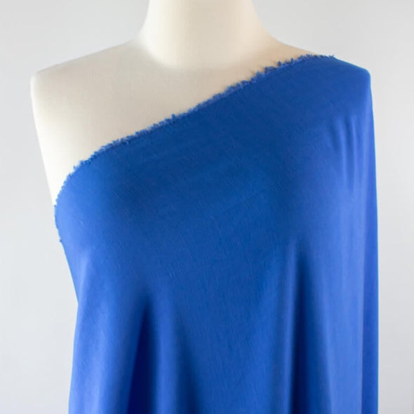 You'll be feeling the summer vibes in this Polynesian blue linen blend.  It has a soft, textured hand and the familiar drape of rayon. Make up a gorgeous top, dress or skirt that stands out!  Translucent with a pleasing slubbed texture, may need lining for dresses and skirts. Image of fabric draped on dress form.