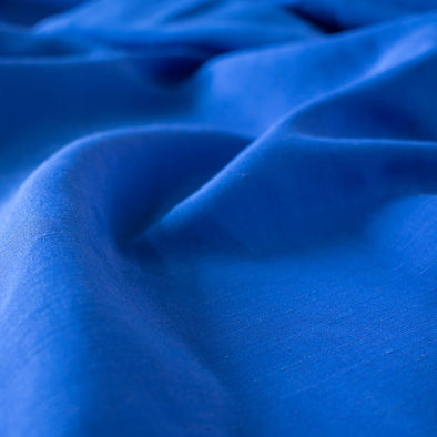You'll be feeling the summer vibes in this Polynesian blue linen blend.  It has a soft, textured hand and the familiar drape of rayon. Make up a gorgeous top, dress or skirt that stands out!  Translucent with a pleasing slubbed texture, may need lining for dresses and skirts. Close up image.