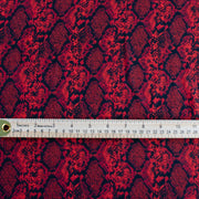 Whip yourself a stunning dress or top in this sophisticated designer deadstock animal print with a stunning red background. Photo of fabric design with ruler to demonstrate scale of animal print pattern.