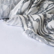 Close up photo , selvedge edge of soft animal print in a sophisticated palette of eggshell and shades of grey from a Los Angeles designer.