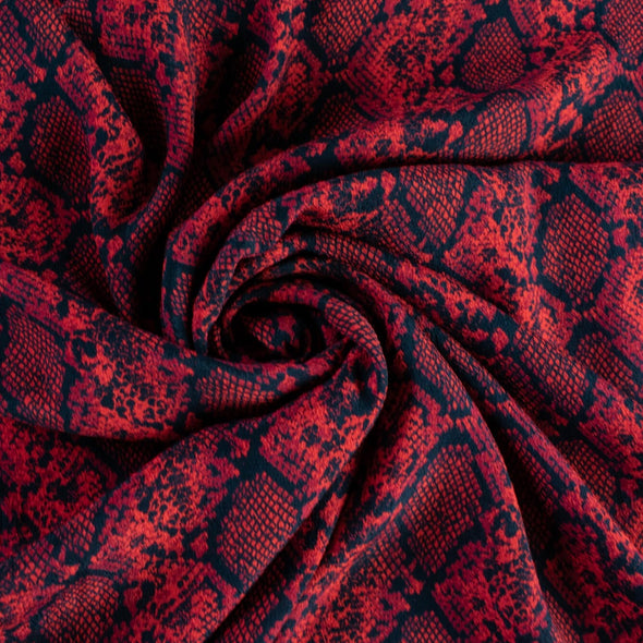 Whip yourself a stunning dress or top in this sophisticated designer deadstock animal print with a stunning red background. Close up photo of swirled fabric to show fullness.