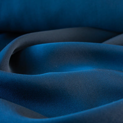 NYC Designer luxuriously deep sea blue 100% silk crepe de chine in a fantastic width. The color of this silk is just stunning! A sophisticated deep blue that would make up a beautiful dress or blouse. Close up photo.