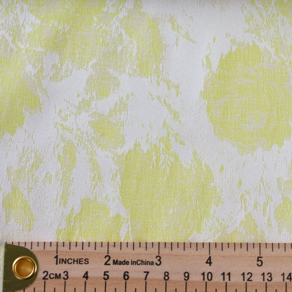designer stretch floral jacquard fabric in lime green and white. Create a statement piece with this stunning fabric. Image of fabric with ruler for scale of print.