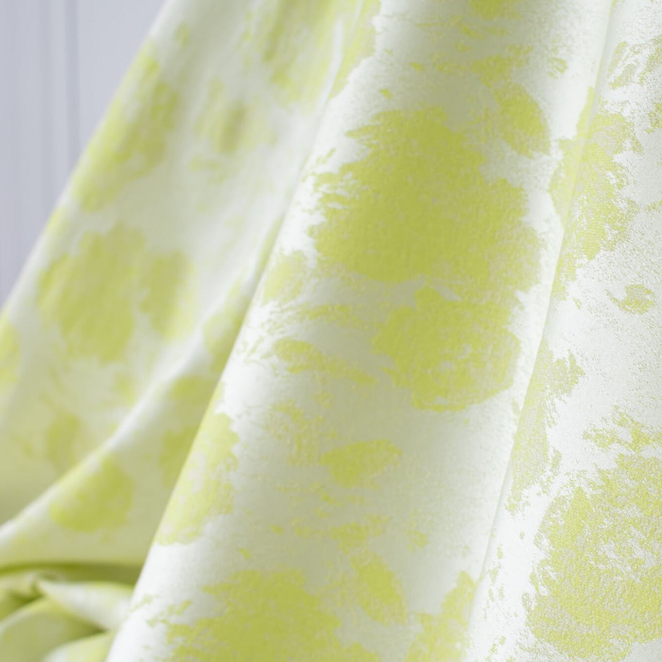 designer stretch floral jacquard fabric in lime green and white. Create a statement piece with this stunning fabric. Image of fabric drape.