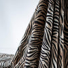 Famous Designer Rayon Challis flowy and soft animal print in tan white and black. Photo depicts fabric drape.  