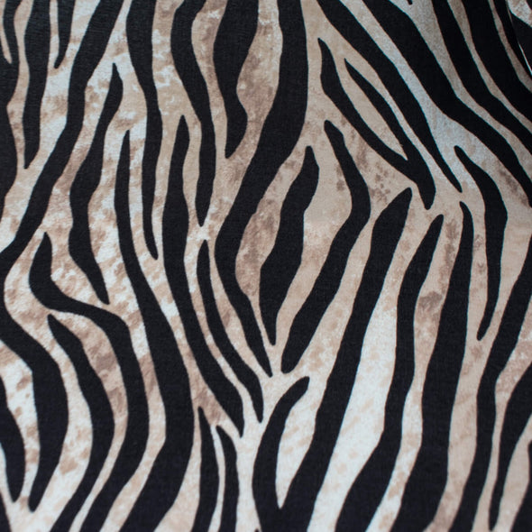 Famous Designer Rayon Challis flowy and soft animal print in tan white and black. Photo  shows fabric print.