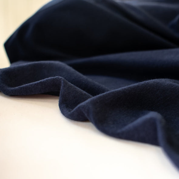 Designer blue modal cotton spandex knit Modal is smoother and softer than rayon viscose and is durable, breathable and shrink resistant. Best of all you'll love how it feels when you wear it! This would make up a lovely wrap top, cami or favorite T-shirt.  Image of fabric selvedge.